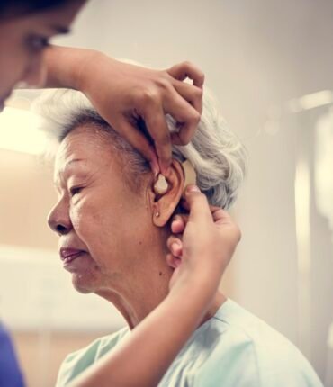 An elderly woman with hearing aid